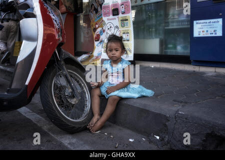 In Tailandia la povertà. Bambino mangiare sul marciapiede in un centro Thai delle baraccopoli. Thailandia poveri. S. E. Asia Foto Stock