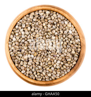 Sementi di canapa in una ciotola di legno su sfondo bianco. Senza guscio commestibili hempseeds greggio della Cannabis sativa. Isolato vicino la macro. Foto Stock