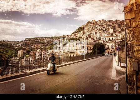 In sella a un iconico scooter italiano a Modica, a sud della Sicilia Foto Stock