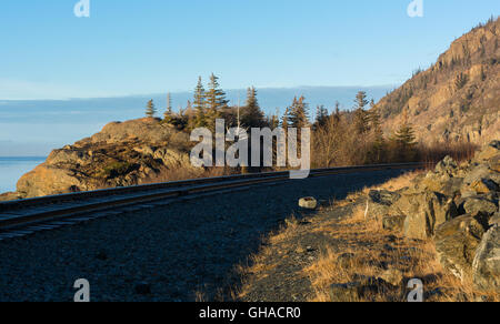 Un insieme di tracce curve intorno un ansa rocciosa con cielo blu in background Foto Stock