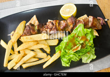 Souvlaki greco con pita - carne di maiale con patate fritte Foto Stock