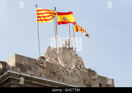 Barcellona, Spagna Municipio facciata in pietra stemma con le bandiere. Casa de la Ciutat nel centro del quartiere gotico con bandiere di Foto Stock