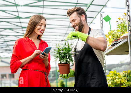 Venditore di fiori con acquirente nel negozio Foto Stock