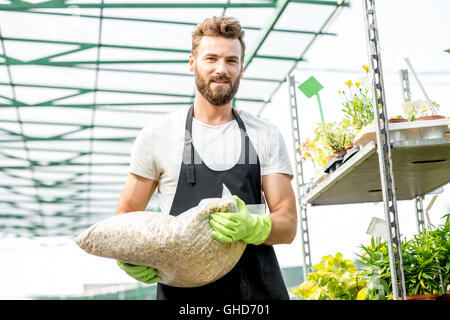 Bello il giardiniere con la sacca di suolo Foto Stock