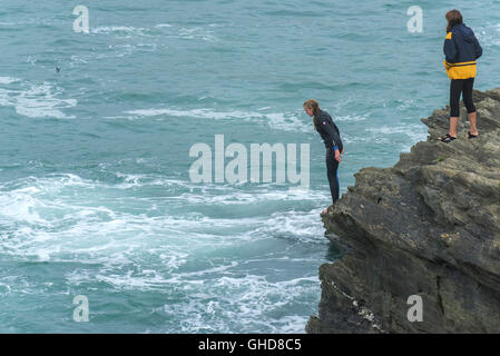 Una giovane ragazza tombstoning off scogliere su Towan promontorio in Newquay, Cornwall. Foto Stock