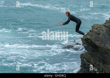 Un adolescente tombstoning off scogliere su Towan promontorio in Newquay, Cornwall. Foto Stock