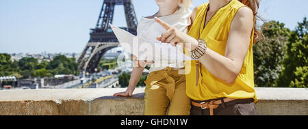 Avente tempo di divertimento nelle vicinanze della famosa pietra miliare in Parigi. Sorridendo la madre e il bambino turisti azienda mappa e puntando a Parigi, Francia Foto Stock