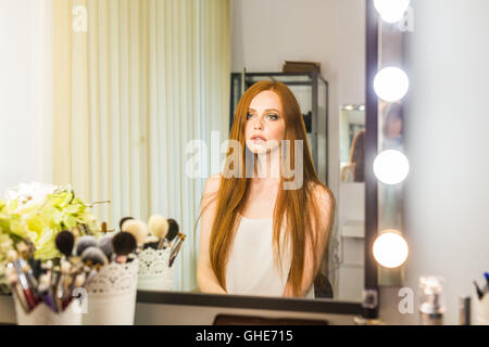 Ritratto di giovane attraente donna guarda nello specchio Foto Stock