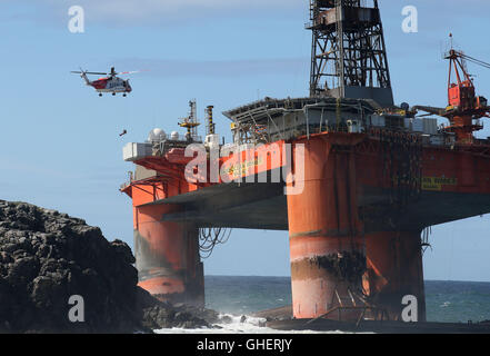 Una guardia costiera elicottero verricelli un esperto di recupero a bordo della Transocean vincitore piattaforma di perforazione dopo che esso si è arenata in condizioni climatiche severe al largo dell'isola di Lewis Foto Stock