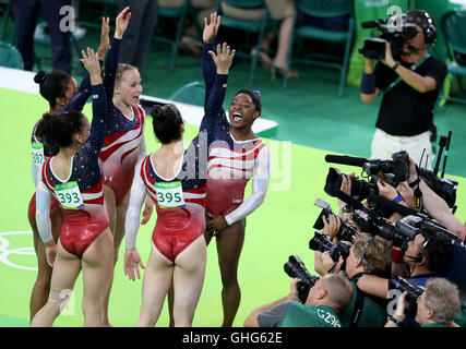 Stati Uniti d'America's Simone Biles (destra) e compagni di squadra celebrare vincere l'oro nel femminile della squadra di ginnastica finale al Rio Olympic Arena il quarto giorno del Rio Giochi Olimpici, Brasile. Foto Stock