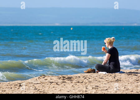 Bournemouth Dorset, Regno Unito. Il 28 settembre 2016. Donna con cuffie seduta rilassante in riva al mare a Bournemouth Beach su un glorioso giorno caldo e soleggiato. Credito: Carolyn Jenkins/Alamy Live News Foto Stock