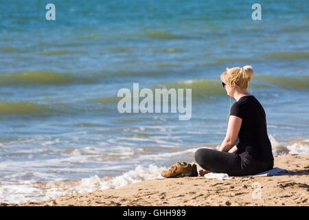 Bournemouth Dorset, Regno Unito. Il 28 settembre 2016. Donna con cuffie seduta rilassante in riva al mare a Bournemouth Beach su un glorioso giorno caldo e soleggiato. Credito: Carolyn Jenkins/Alamy Live News Foto Stock
