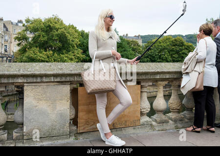 Bath, Regno Unito, 28 settembre, 2016. Oggi il clima caldo ha attirato grandi folle di visitatori al bagno,una donna è raffigurato prendendo un selfie nella parte anteriore della vasca da bagno il famoso Pulteney Bridge. Credito: lynchpics/Alamy Live News Foto Stock
