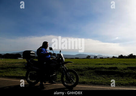 Heredia, Costa Rica. 28 Sep, 2016. Un motociclista guarda la colonna di cenere del vulcano Turrialba all'Aeroporto Internazionale di Juan Santamaria, nella provincia di Alajuela, Costa Rica, sul Sett. 28, 2016. © Kent Gilbert/Xinhua/Alamy Live News Foto Stock