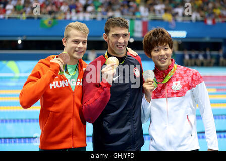 Medaglia d'oro USA Michael Phelps (centro) argento medaglia del Giappone Masato Sakai (a destra) e la medaglia di bronzo dell'Ungheria Tamas Kenderesi dopo gli Uomini 200m Butterfly finale alla Olympic Aquatics Stadium il quarto giorno del Rio Giochi Olimpici, Brasile. Foto Stock