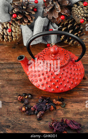 Rosso teiera in metallo,le foglie di tè e autunno pigne Foto Stock