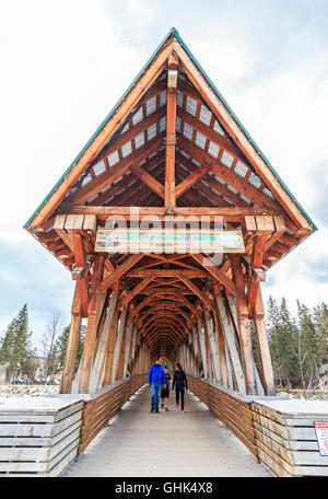 La famiglia passeggiate attraverso Kicking Horse ponte pedonale oltre il Fiume Kicking Horse nella città di Kicking Horse, BC, Canada. Foto Stock