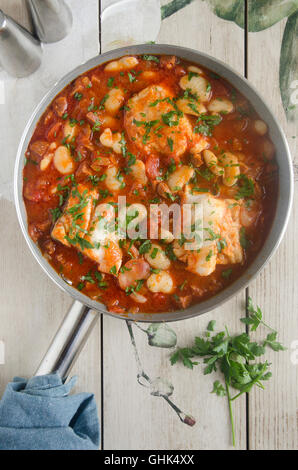 Merluzzo bianco, il Chorizo e il burro stufato di fagioli in una padella Foto Stock