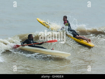 Surfers e tavole da surf, kayak e canoe, vita di spiaggia e giornate estive Foto Stock