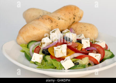 Insalata greca con il formaggio Feta contenente pomodori, cetrioli e lattuga, peperoni e olive nere condite con Zaatar e servita w Foto Stock