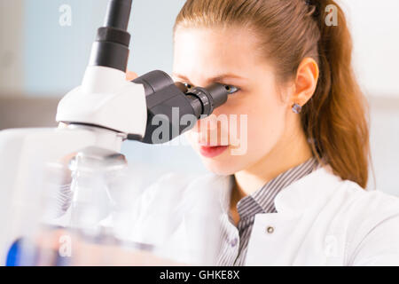 Giovane donna. assistente di laboratorio guardando della sperimentazione biologica Foto Stock