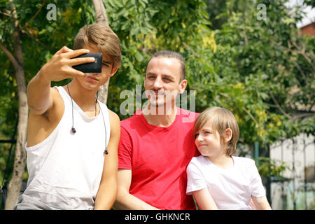 Padre e i due figli che posano per una foto selfie Foto Stock