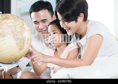 Giovani genitori asiatici ad esplorare il mondo con il loro bambino. Foto Stock