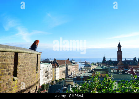 I Capelli rossi ragazza sulla sommità della torre si gode della vista di Helsinborg, Svezia Foto Stock