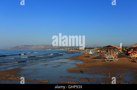 Vacanzieri godere il tardo pomeriggio di sole su di una spiaggia di Georgioupolis, Creta. L'isola greca sta godendo di un boom del turismo Foto Stock