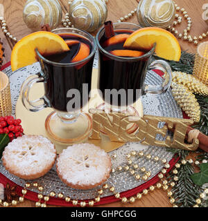 Natale ancora vita con oro glitter noel segno, vin brulè, pasticci di carne macinata, pomander arancione e oro ninnolo decorazioni. Foto Stock