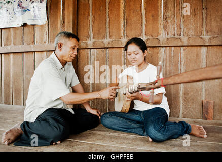 Musicista Master uomo uomini insegna uno studente .nozze classica musica sul suo Chapei Dang Weng. Un cambogiano a collo lungo liuto...l'uomo M Foto Stock