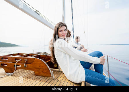 Giovane donna rilassante sulla coperta della barca di yacht Foto Stock