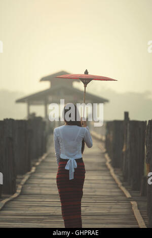 Da sola donna che cammina da sola su U Bein birdge myanmar Foto Stock