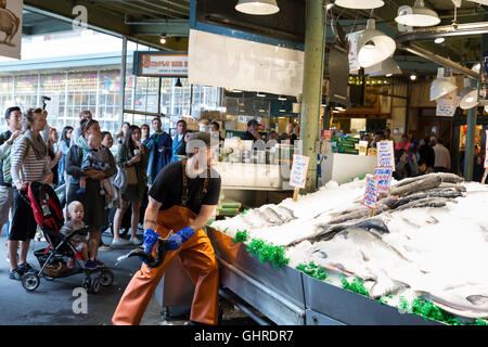 Seattle, Washington: Ryan gettando un pesce a Pike Place Mercato del Pesce. Foto Stock