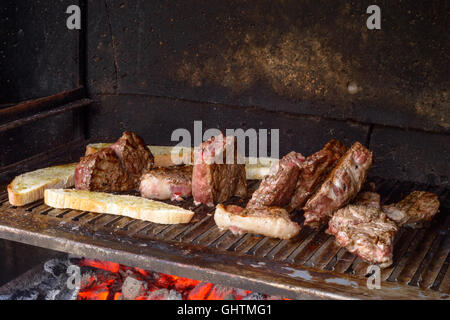 Molti pezzo di carne di manzo e di pane bruschetta grigliare su un barbecue Foto Stock