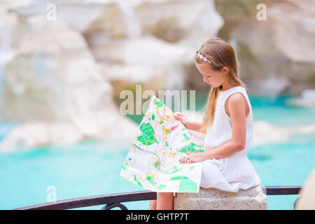 Adorabile bambina guardando mappa turistica vicino a Fontana di Trevi, Roma, Italia. Felice toodler kid godere di vacanza italiana vacanza in Europa. Foto Stock