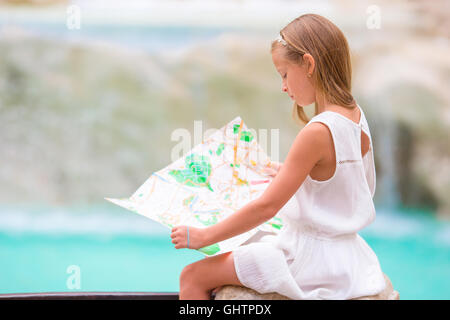 Adorabile bambina guardando mappa turistica vicino a Fontana di Trevi, Roma, Italia. Felice toodler kid godere di vacanza italiana vacanza in Europa. Foto Stock