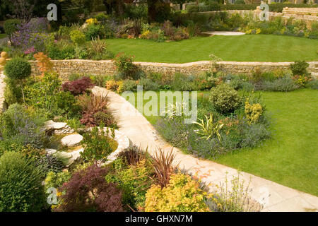 Regno Unito. Un nuovo giardino con arbusti in confini e nuovi paesaggi di pietra calcarea. Foto Stock