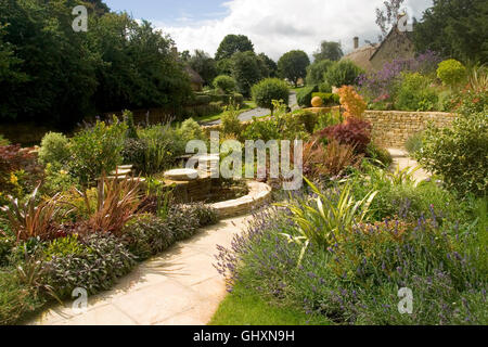 Regno Unito. Un nuovo giardino con arbusti in confini e nuovi paesaggi di pietra calcarea. Foto Stock