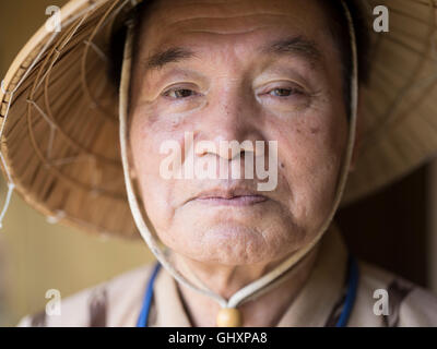 Anziani Okinawense l uomo nella sua 70's indossando il tradizionale stile bashofu kimono e cappello di paglia. Okinawa è una longevità zona blu. Foto Stock