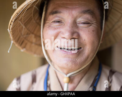 Anziani Okinawense l uomo nella sua 70's indossando il tradizionale stile bashofu kimono e cappello di paglia. Okinawa è una longevità zona blu. Foto Stock