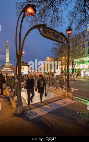 Un giovane all'entrata della metropolitana di Place de la Bastille a crepuscolo, Parigi, Francia Foto Stock
