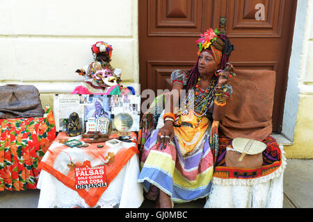 Senora Habana, una sacerdotessa di afro-cubano Santeria con colorati a lungo chiodi e un sigaro. Foto Stock