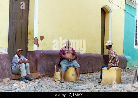 Tre uomini seduti a chattare su bitte in strada, l'Avana, Cuba, 2013 Foto Stock