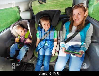 Felice i passeggeri seduti sul backseats di una automobile Foto Stock