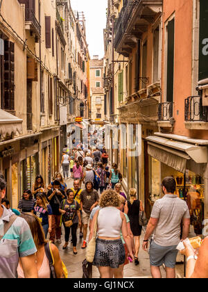 Turistiche e gli acquirenti in una stretta strada di Venezia, Italia. Foto Stock