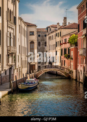 Stretto canale deserte e edifici tradizionali con barche ormeggiate. Venezia, Italia. Foto Stock