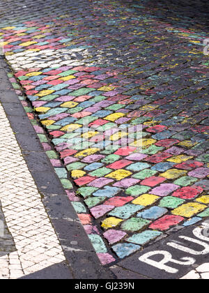 Colorato i ciottoli. I ciottoli di Ponta Delgada street dipinte a vivaci colori primari. Foto Stock