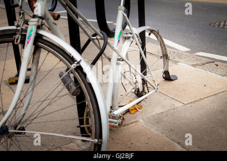 Una vecchia bicicletta con perso o rubato o mancanti ruota posteriore fissata ad un montante. Londra, 2016. Foto Stock