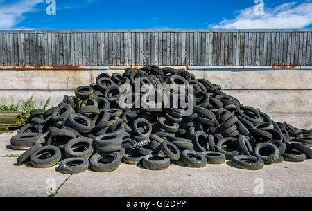 Una pila di vecchi pneumatici usati in un cantiere. Foto Stock